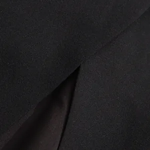 Vista macro de la textura de la tela negra y costuras de calidad en la abertura de la falda.
