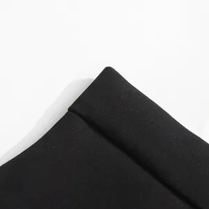 Primer plano detallado de la textura fina de la tela de la falda negra de talle alto