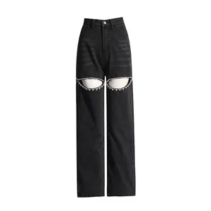 Detailed view of high-waisted black wide-leg jeans with unique rhinestone cut-out accents.