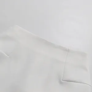 Dettaglio ravvicinato della vita di una gonna bianca a trapezio che mostra le cuciture.