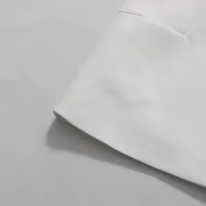 Dettaglio ravvicinato del tessuto bianco di alta qualità e dell'orlo pulito del set gonna.