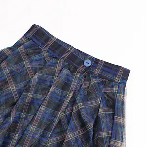 Close-up of high waist plaid skirt with mesh stitching and blue button detail