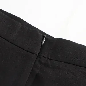 Detalle de primer plano de la cremallera invisible en esta elegante falda negra de talle alto.