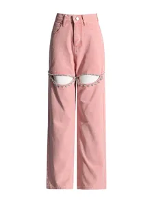 Detail view of pink high-waisted wide-leg jeans with rhinestone-trimmed thigh cutouts