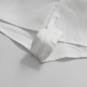 Primo piano dettagliato delle cuciture in tessuto bianco e dell'orlo su una minigonna elegante