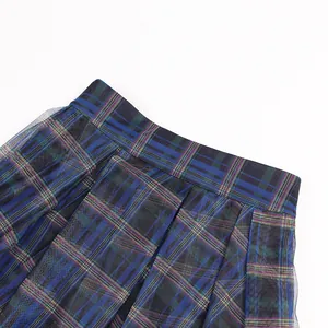 Close-up of high waist pleated plaid skirt with elegant black mesh overlay detailing