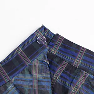 Detail of high waist plaid skirt showing transparent button and mesh overlay texture