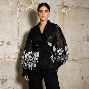 Detailed shot of a black palace style shirt with lantern sleeves and floral print.