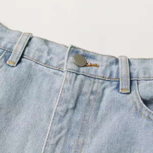 Close-up of light blue high-waisted denim jeans showing button and fabric texture details