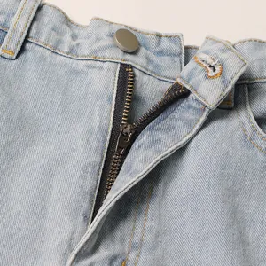 Close-up of zipper and metal button on light blue high-waisted wide-leg denim jeans