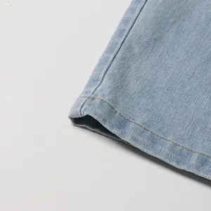 Detail shot of the precisely stitched hem on these light blue denim wide-leg jeans.