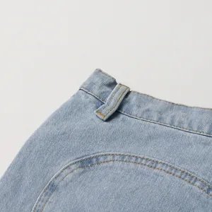 Detailed macro view of light blue high waist denim jeans with yellow stitching