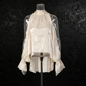Vista detallada de la elegante blusa champán con hombros descubiertos y cuello alto
