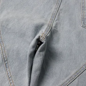 Close-up detail of light blue denim jeans showing stitching and hidden zipper