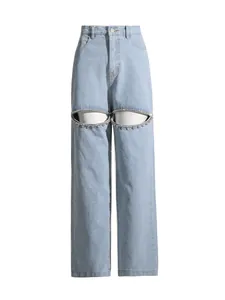 Light blue high-waist denim jeans with rhinestone eye-shaped cut-out design at knees