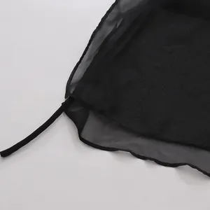 Gros plan sur le tissu en maille transparente noire et la sangle réglable du gilet mode