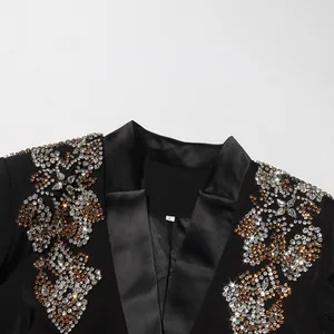 Gros plan des motifs en strass sur le revers d'un blazer noir avec col en V