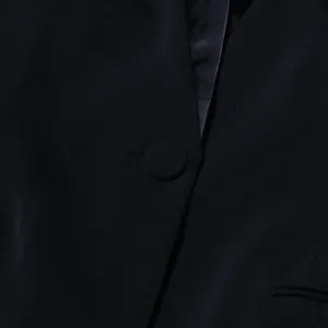 Vue détaillée d'un élégant blazer noir pour femme avec bouton rond recouvert de tissu