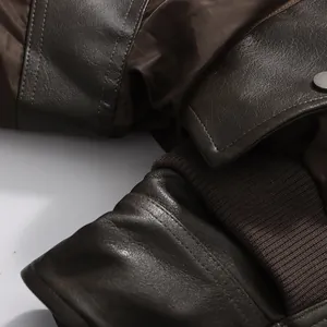 Close-up of the brown leather texture and ribbed knit cuff details on a women's jacket.