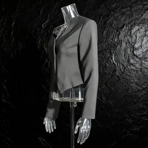 Detail van grijze asymmetrische blazer met getailleerde taille en mouwtextuur