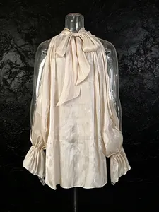 Elegante blusa de satén champán con hombros descubiertos, lazo grande y mangas acampanadas