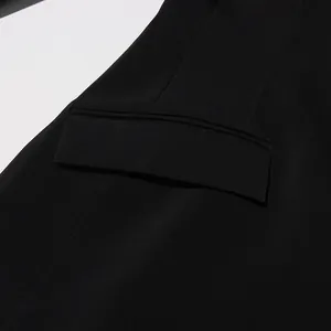 Gros plan détaillé montrant la poche à rabat et les coutures d'un blazer noir pour femme