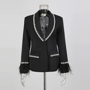 Detail of black blazer featuring ostrich feather cuffs and rhinestone trim accents