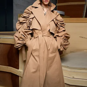 Detail view of khaki trench coat with dramatic ruffled puff sleeves and wide lapels.