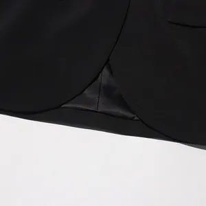 Détail de haute qualité de l'ourlet d'un blazer noir avec une doublure en satin lisse