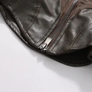 Macro view of metallic zipper and brown leather texture on a vintage cropped jacket