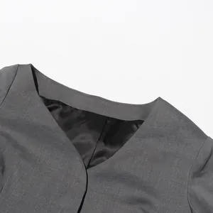 Gedetailleerde close-up van de elegante grijze blazer met asymmetrische hals en voering