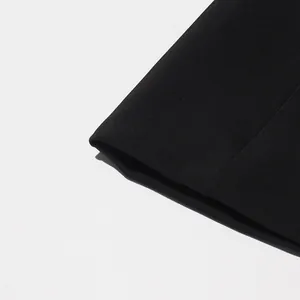 Gros plan sur le revers de manche d'un blazer noir élégant montrant le tissu de qualité
