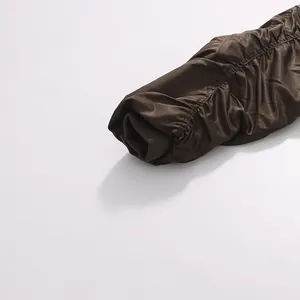 Detailed macro view of pleated jacket sleeve with elastic ribbed cuff in vintage brown