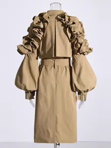 Rear view of khaki trench coat showing dramatic ruffle details and puff sleeve buckles