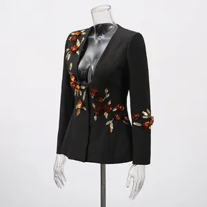 Detail of black women's blazer with 3D bronze floral embroidery and golden leaves embellishment.