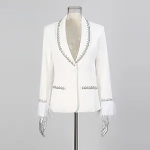 Detailed view of an elegant white blazer with rhinestone trim and feather cuffs