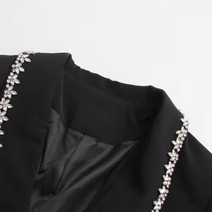 Close-up view of elegant black blazer featuring intricate floral rhinestone lapel detail