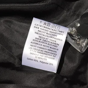 Gros plan sur l'étiquette d'entretien et les strass de rechange pour ce blazer chic