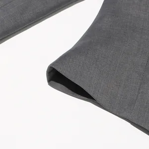 Macro-opname van hoogwaardige grijze twill-stoftextuur en stiksels bij de manchetten.