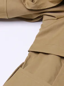 Close-up of khaki trench coat featuring high-quality fabric texture and flounce detail