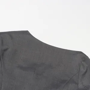 Detailopname van de elegante asymmetrische halslijn op een grijze verfijnde blazerjas