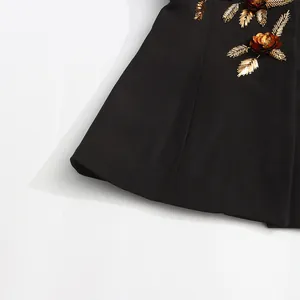 Detailed close-up shot of heavy 3D beaded floral embroidery on a black blazer jacket
