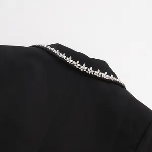 Close-up of elegant black blazer collar with intricate rhinestone leaf embellishments