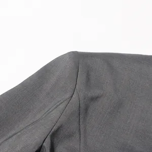 Gedetailleerde macro-opname van de schouder en schuine halslijn van een grijze blazer
