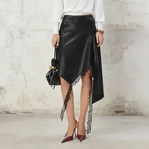 Detailed view of an asymmetrical black faux leather skirt featuring elegant lace trim
