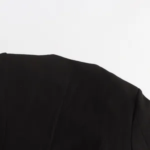 Close-up detail of the sharp shoulder and tailored back seam of a black designer blazer