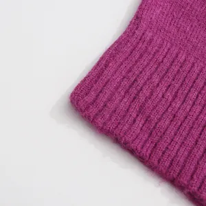 Close-up of the ribbed cuff texture on a soft magenta French style knit sweater