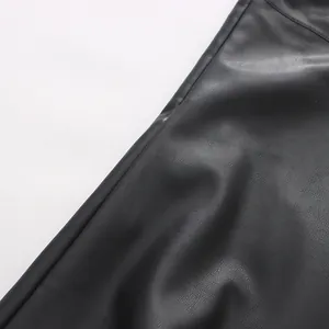 Close-up detail of black faux leather skirt showcasing the fine grain texture and stitching