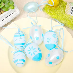 Juego decorativo de seis huevos de Pascua pintados en azul y blanco con cintas en plato
