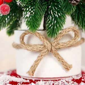 Mini artificial Christmas tree in white pot with twine bow and red berry accents